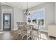 Bright dining area with a white table set, elegant chandelier, and a view through large windows at 128 Seabreeze Dr., Murrells Inlet, SC 29576