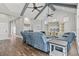 Bright living room featuring a vaulted ceiling with beams, modern ceiling fans, and comfortable blue seating at 128 Seabreeze Dr., Murrells Inlet, SC 29576