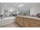 Bright bathroom featuring a bathtub, vanity with double sinks, and neutral accents at 128 Waterway Crossing Ct., Little River, SC 29566