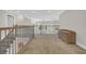 Hallway featuring carpet, wood railing, and view to the main floor of the home at 128 Waterway Crossing Ct., Little River, SC 29566