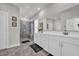 Bright bathroom with a large mirror, double sink vanity, and tiled walk-in shower with built-in bench at 1317 Captain Hooks Way, North Myrtle Beach, SC 29582