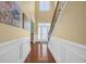 Bright foyer with hardwood floors, white wainscoting, staircase, and a large front door with transom window at 132 Summerlight Dr., Murrells Inlet, SC 29576