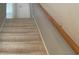 Carpeted staircase with wooden handrail leads to the upper level of the home at 1413 Cane St. # 1, North Myrtle Beach, SC 29582