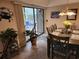 Bright dining area with a wooden table and chairs, leading to an outdoor patio with a serene view at 14A Salt Marsh Cove # 14A, Pawleys Island, SC 29585