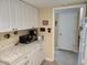 Kitchen area with white cabinetry, marble countertops, coffee maker, and refrigerator at 14A Salt Marsh Cove # 14A, Pawleys Island, SC 29585