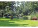 Scenic view of a tranquil pond surrounded by lush greenery and trees, with a bench for relaxation at 14A Salt Marsh Cove # 14A, Pawleys Island, SC 29585