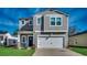 Charming two-story home with gray siding, a well-manicured lawn, and an attached two-car garage at 1527 Swing Bridge Way, Myrtle Beach, SC 29588