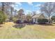 This is a backyard with a brick patio, mature trees, and lawn at 17 Racquet Club Dr., Pawleys Island, SC 29585