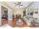 Cozy sunroom featuring hardwood floors, large windows, ceiling fan, and comfortable seating at 17 Racquet Club Dr., Pawleys Island, SC 29585