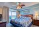 Comfortable bedroom with a ceiling fan, ocean view, and sliding glass doors to a balcony at 1903 S Ocean Blvd. # 701, North Myrtle Beach, SC 29582