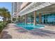 Inviting outdoor pool area beneath a modern building, featuring a clean design and brickwork surrounding the pool at 1903 S Ocean Blvd. # 701, North Myrtle Beach, SC 29582