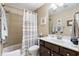 Well-lit bathroom featuring a shower-tub combo with neutral tile, a vanity with lots of space and a large mirror at 2122 Silver Spring Ln., Myrtle Beach, SC 29577