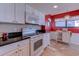 Well-lit kitchen with white cabinets, black granite countertops, and modern appliances at 2307 S Ocean Blvd. # 5A, North Myrtle Beach, SC 29582