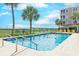 Sparkling community swimming pool surrounded by lounge chairs and palm trees offers a resort-like experience at 2307 S Ocean Blvd. # 5A, North Myrtle Beach, SC 29582