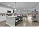 Modern kitchen with white cabinets, a large island, and stainless steel appliances, seamlessly connecting to the living area at 235 Calhoun Falls Dr., Myrtle Beach, SC 29579