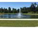 Scenic view of a serene pond with a fountain, surrounded by lush trees and greenery at 235 Calhoun Falls Dr., Myrtle Beach, SC 29579