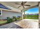 Covered back patio with ceiling fan overlooking a serene lake and landscaping at 2381 Tidewatch Way, North Myrtle Beach, SC 29582