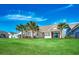 Lush backyard with well-manicured lawn, palm trees, and the home's rear facade at 2381 Tidewatch Way, North Myrtle Beach, SC 29582