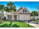 Charming single Gathering home with lush green lawn, palm trees, and an attached two car garage at 2381 Tidewatch Way, North Myrtle Beach, SC 29582