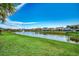 Scenic view of a tranquil pond surrounded by lush green lawns and colorful homes at 2381 Tidewatch Way, North Myrtle Beach, SC 29582