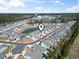 Expansive aerial shot of a community with modern homes, a central pond, and scenic green surroundings at 2408 Blue Crane Circle, Myrtle Beach, SC 29577