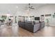 Bright living room with a large gray sofa, hardwood floors, and several windows at 2408 Blue Crane Circle, Myrtle Beach, SC 29577