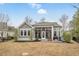 View of the back of the home with a spacious screened-in patio, stone patio, and lawn area at 2409 Silkgrass Ln., Myrtle Beach, SC 29579