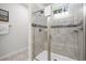 Bathroom featuring a tiled shower with a glass door, built-in bench, and window at 2557 Pete Dye Dr. # 702, North Myrtle Beach, SC 29582