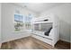 Bright bedroom featuring a white bunk bed, wood floor, and window with neighborhood views at 2557 Pete Dye Dr. # 702, North Myrtle Beach, SC 29582