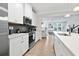 Modern kitchen with white cabinetry, stainless steel appliances, and a view into the living area at 2557 Pete Dye Dr. # 702, North Myrtle Beach, SC 29582