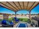 Relaxing back patio with wicker furniture set under a shaded pergola overlooking the well-manicured lawn at 257 Leste Rd., Myrtle Beach, SC 29588