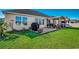 Grassy backyard with a pergola-covered patio area, outdoor grill, and views of the home's exterior at 257 Leste Rd., Myrtle Beach, SC 29588