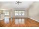 Spacious living room with hardwood floors, ceiling fan, and large windows at 2960 Tigers Eye Rd., Little River, SC 29566