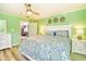 Bright bedroom with green walls, ceiling fan, wood-look floors, and a cozy bed with patterned bedding at 308 24Th Ave. N, North Myrtle Beach, SC 29582