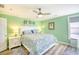 Bright bedroom with green walls, ceiling fan, wood-look floors, and a cozy bed with patterned bedding at 308 24Th Ave. N, North Myrtle Beach, SC 29582