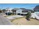 Well-maintained exterior of an elevated beach home with a large driveway and covered carport at 308 24Th Ave. N, North Myrtle Beach, SC 29582