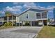 Coastal home on stilts featuring a paved driveway and screened-in porch for outdoor relaxation at 308 24Th Ave. N, North Myrtle Beach, SC 29582