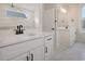 Bright bathroom featuring double vanity with white cabinets, black hardware, and marble tile flooring at 319 Crossing Ct., Myrtle Beach, SC 29588