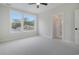 Spacious bedroom featuring a ceiling fan, large window, and neutral carpet at 319 Crossing Ct., Myrtle Beach, SC 29588