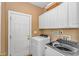 Laundry room with front loading washer and dryer, white cabinets and utility sink at 359 Rose Ave., Georgetown, SC 29440