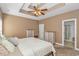 Warm, inviting bedroom featuring tray ceiling, neutral tones, and ensuite bathroom at 359 Rose Ave., Georgetown, SC 29440