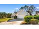 Well-maintained driveway leading to a two-car garage, surrounded by lush greenery and mature trees at 1501 Hallborough Dr., Surfside Beach, SC 29575