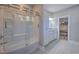 Bright bathroom with a glass-enclosed shower/tub combo, white vanity, granite countertops, and neutral tile flooring at 377 Waties Dr., Murrells Inlet, SC 29576