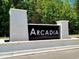 Arcadia community entrance sign with white brick pillars and lush green trees at 4019 Bucolic Loop, Myrtle Beach, SC 29588