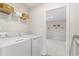 Bright laundry room with washer, dryer, storage shelves, and decorative baskets at 4019 Bucolic Loop, Myrtle Beach, SC 29588