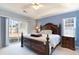 Main bedroom with a tray ceiling, sliding glass doors to the backyard and a decorative dark wood bed frame at 4030 Manor Wood Dr., Myrtle Beach, SC 29588