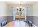 Traditional dining room with chair rail, decorative chandelier and a large window overlooking the backyard at 4030 Manor Wood Dr., Myrtle Beach, SC 29588