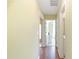 Hallway leading to different rooms, featuring wood floors and light yellow walls at 4030 Manor Wood Dr., Myrtle Beach, SC 29588