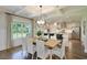 Open-concept dining area with a view of the kitchen featuring coffered ceilings, modern lighting, and a large window at 4060 Bucolic Loop, Myrtle Beach, SC 29588