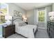 Bright bedroom with a white-striped coverlet, soft gray walls, and a large window overlooking a lush, green landscape at 426 Clear Lake Dr., Conway, SC 29526